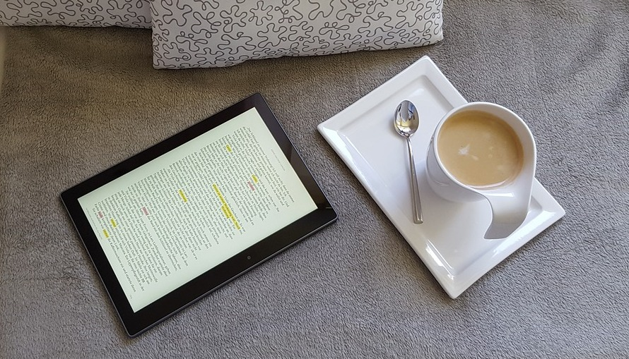 tablet y cafe tablet con texto junto a una taza de cafe